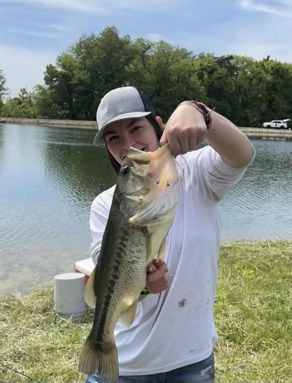 A student holding a large bass