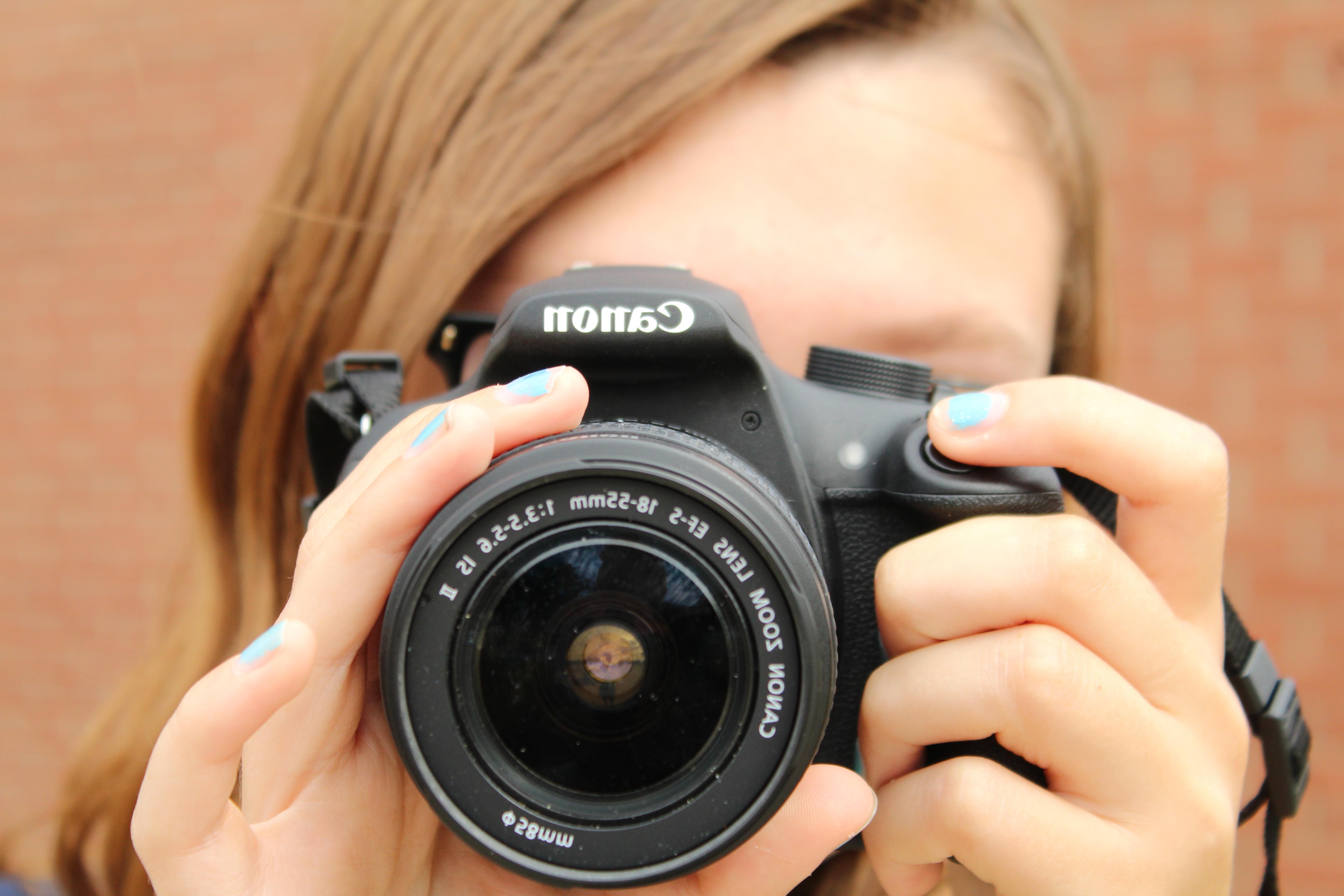 A female student holding a camera